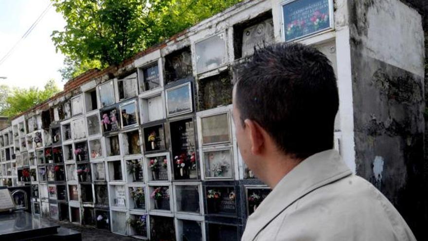 Un vecino ante los 96 nichos que el Arzobispado pretende derribar. Junto a estas líneas, nichos invadidos por la maleza. A la derecha, un árbol que nace sobre las tumbas, en una cornisa a punto de venirse abajo. | nacho orejas