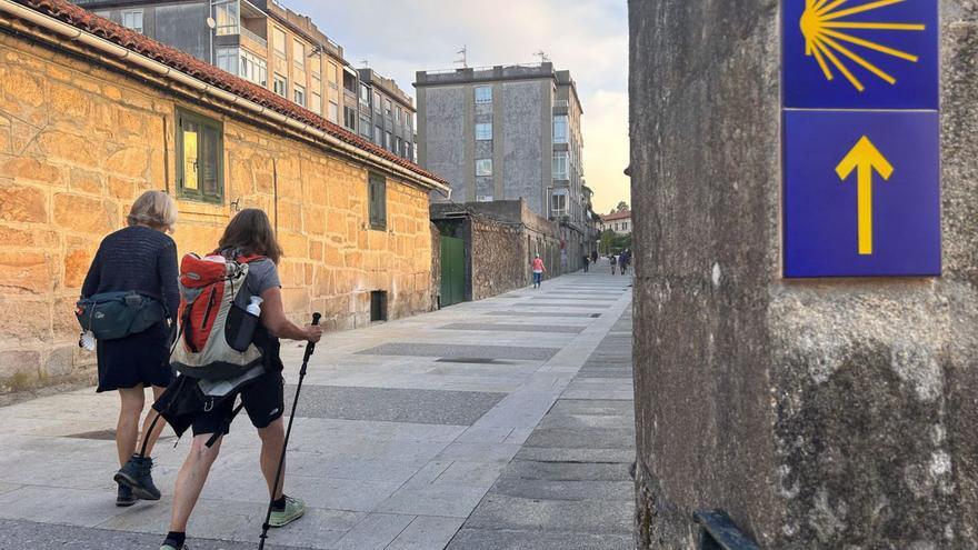 Peregrinos a su paso por la renovada calle Antero Rubín, en Tui.  | // D.P.