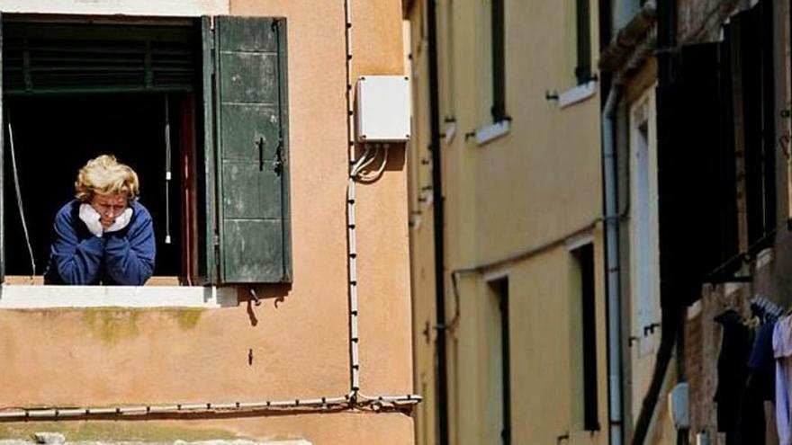 Una dona mirant per la finestra durant la quarantena a Itàlia.