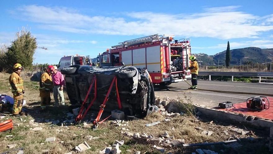 Los bomberos de Dénia excarcelan a una mujer accidentada al volcar su coche cerca de la Marjal Oliva-Pego