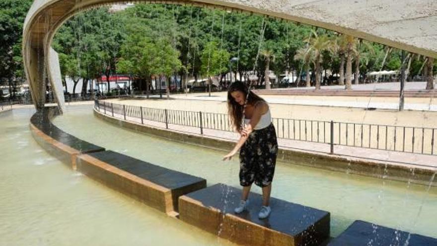 Una joven se refresca en una fuente en el barrio de La Florida de la ciudad de Alicante, ayer a mediodía.