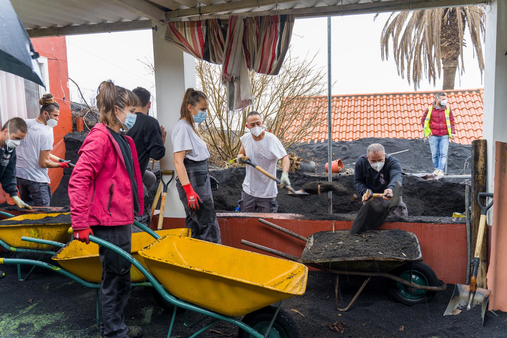 Vecinos y voluntarios trabajan en la zona de Las Manchas retirando ceniza, el 2 de febrero de 2022.