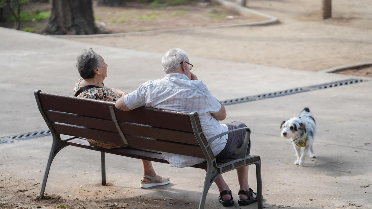 Dos personas mayores sentadas en un banco.