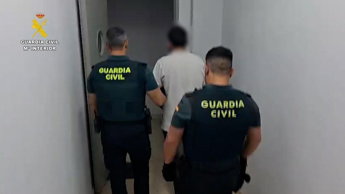 Dos agentes junto al detenido, en dependencias de la Guardia Civil.