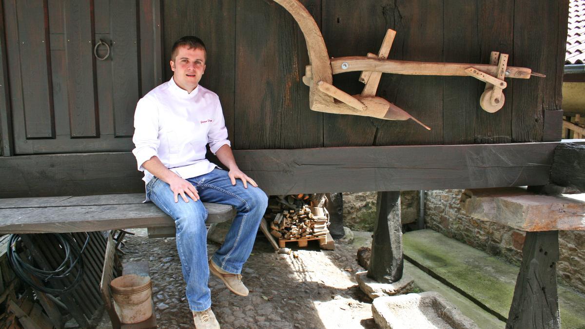 Javier Álvarez Farpón, sentado en la panera familiar, frente a su restaurante en Mamorana (Lena).