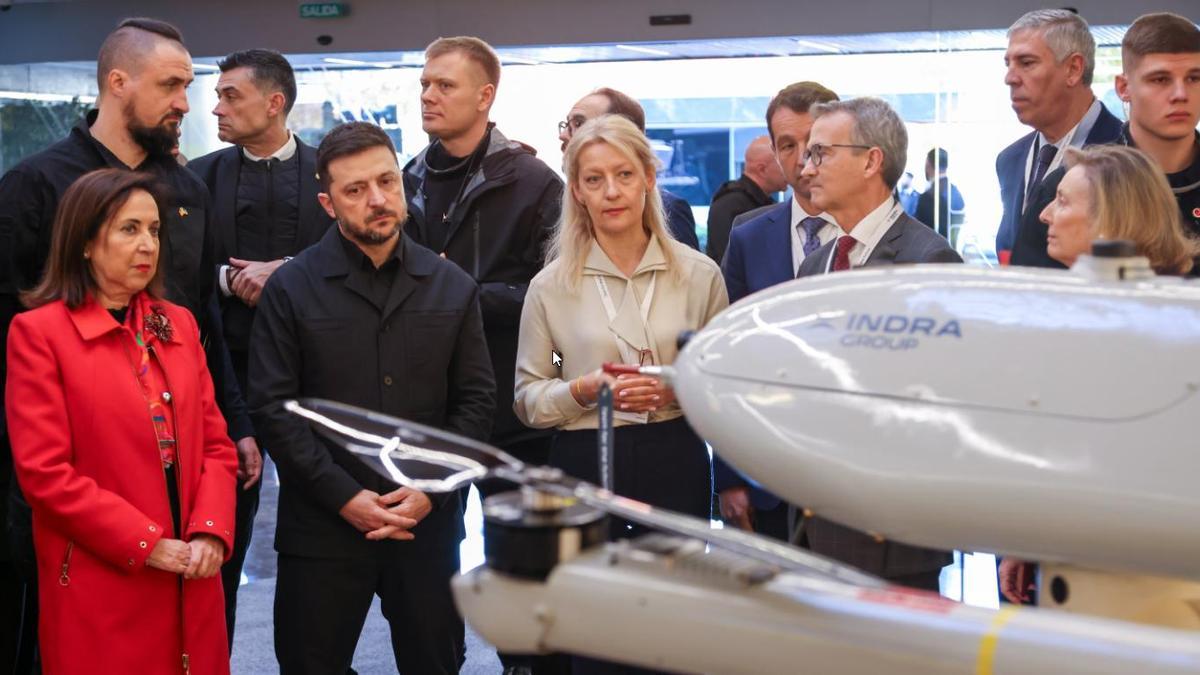 Volodimir Zelenski, junto a la ministra de Defensa, Margarita Robles, y el titular ucraniano de Indsutrias Estratégicas, Oleksandr Kamyshin, durante su visita a instalaciones de INdra este martes.