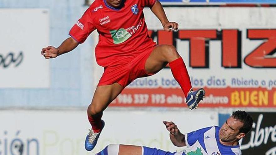 Un jugador del Barbadás salta para evitar el contacto con un defensa del Areas, ayer. // Jorge Santomé