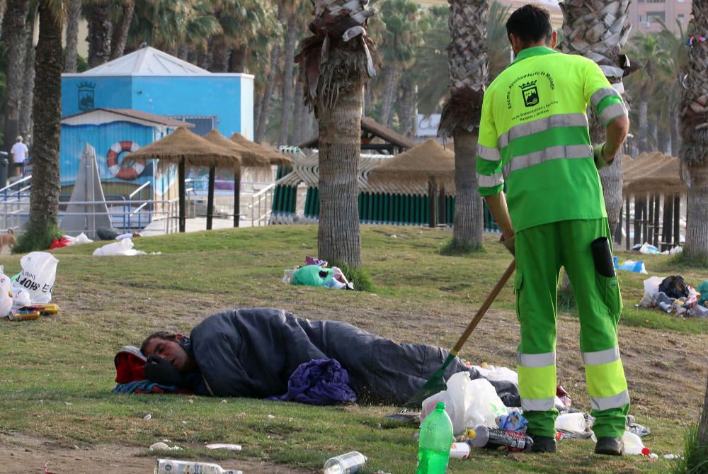 Los operarios de los servicios de limpieza trabajan para dejar la playa en óptimas condiciones tras una larga noche de fiesta en la arena