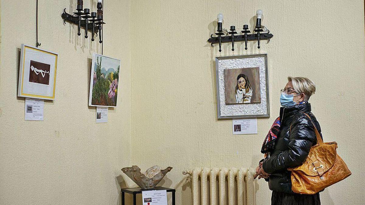 Una mujer observa las obras de arte en la primera planta del Liceo de Ourense.