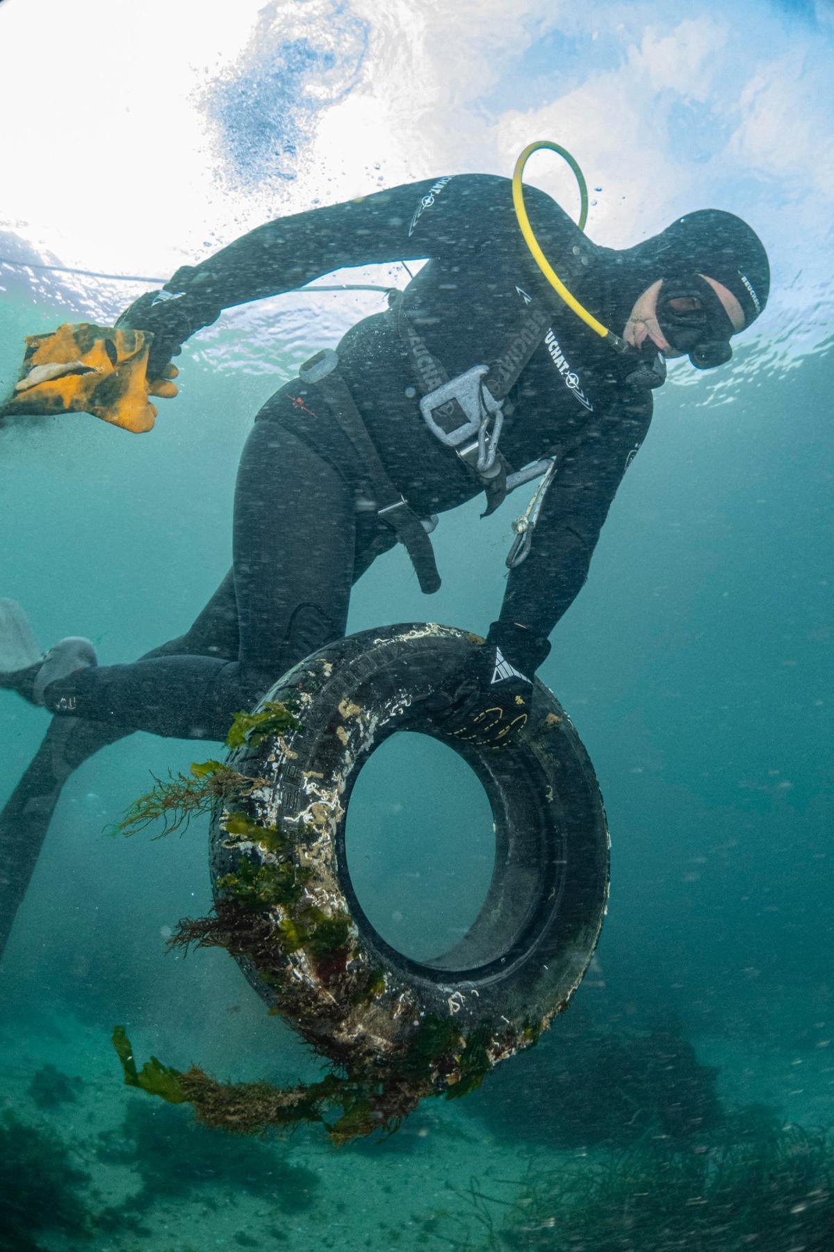 Un submarinista transporta restos de residuos
