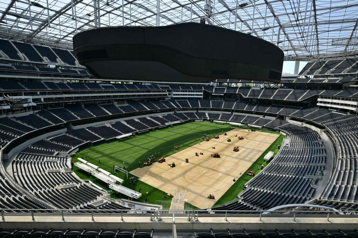 Los trabajadores instalan césped en el campo en el SoFi Stadium en Inglewood, California, antes de su cambio de nombre temporal al Estadio de Los Ángeles para la Copa del Mundo el 13 de mayo de 2026.