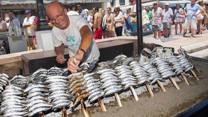 Un espetero  prepara unos espetos de sardinas.