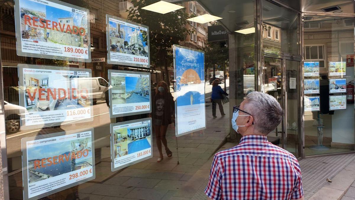 Un hombre lee los anuncios de una inmobiliaria de Vigo. |   // MARTA G. BREA