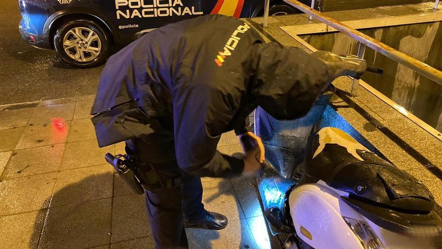 Un policía examina la moto sustraída.