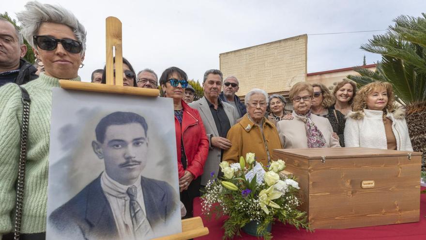 Familiares posan con los restos y un retrato del represaliado en el cementerio de Cartagena. | MARCIAL GUILLÉN