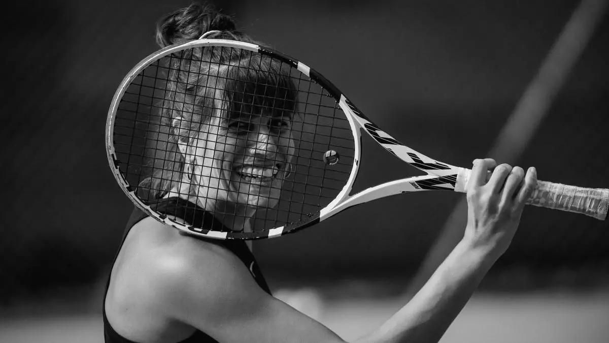María Torres en una pista de tenis, junto a su raqueta.