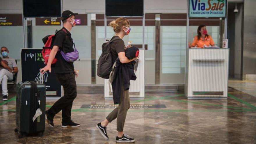 Turistas con mascarilla a su llegada al aeropuerto.