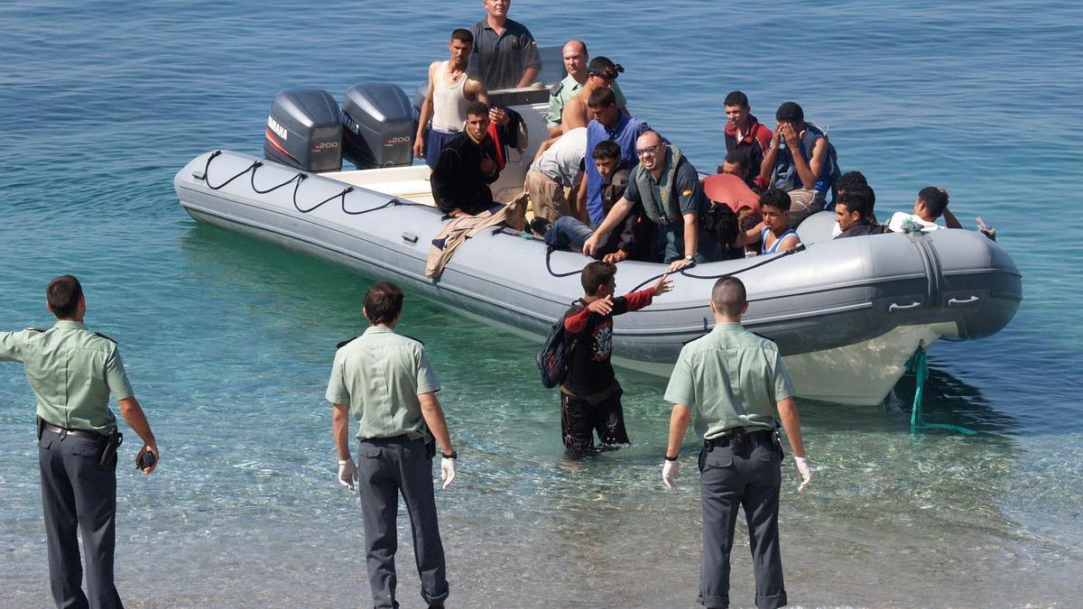 Guardias civiles junto a una zodiac llena de inmigrantes marroquíes llegada a Nerja (Málaga).