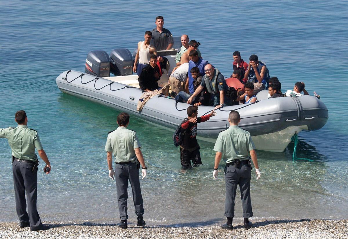 Guardias civiles junto a una zodiac llena de inmigrantes marroquíes llegada a Nerja (Málaga).