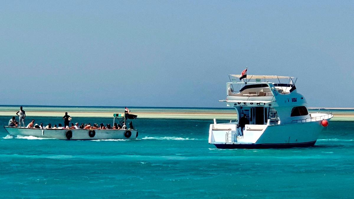 Turistas hacen un recorrido junto a un yate atracado en el puerto deportivo del complejo turístico egipcio de Hurghada, en el mar Rojo, después del naufragio de un barco turístico, este lunes.