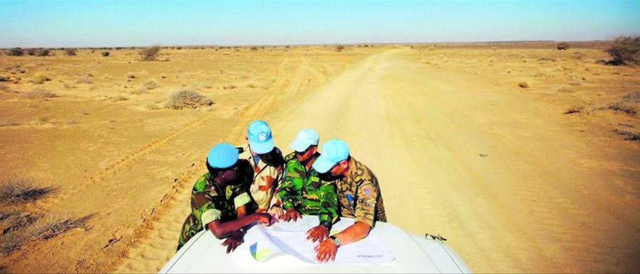 Cuatro militares del cuerpo de pacificación de la Minurso patrullan por una carretera del Sáhara Occidental.
