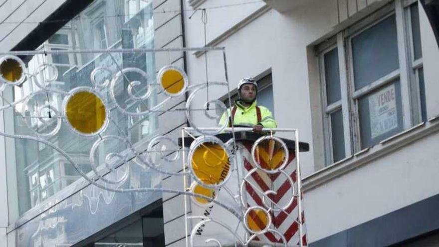 Un operario colocando el alumbrado navideño ayer. // Alba Villar