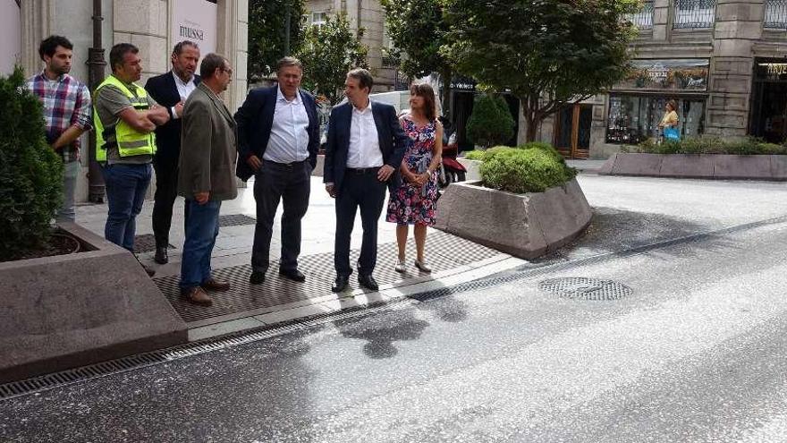 Caballero, junto a los concejales Pardo y Mejías y responsables de la obra, observando el resultado del cambio de adoquines acometido en la calle Carral. // FdV