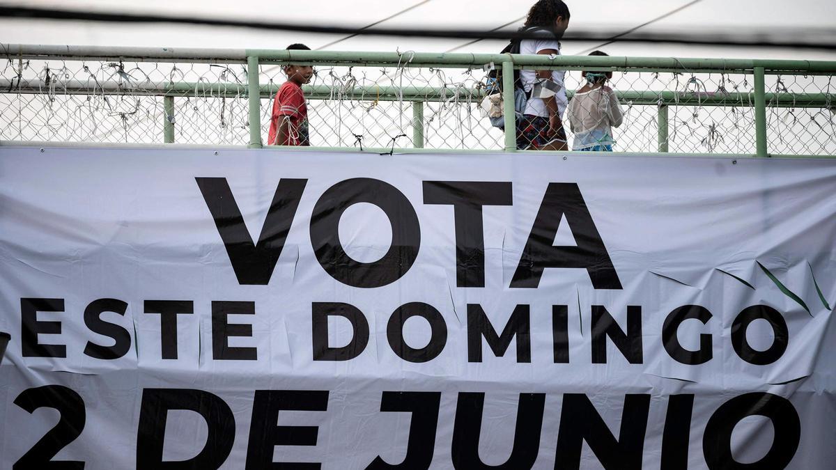 Puente peatonal con un cartel que llama a votar en las elecciones del 2 de junio, en Xochimilco, México