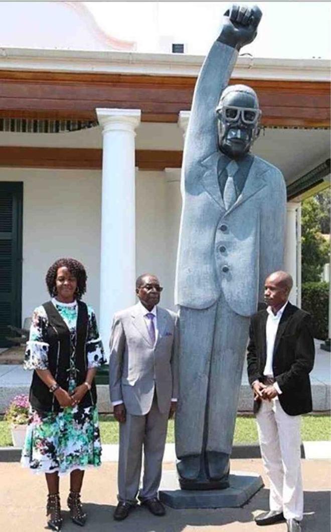 El artista Benhura (a la derecha), posa con el presidente Mugabe y su esposa Grace junto a la polémica estatua.