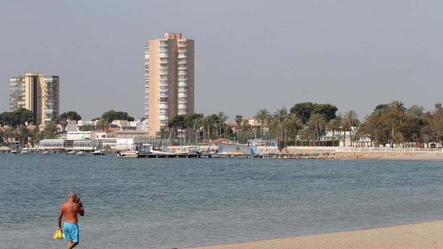 Un hombre pasea por una playa del Mar Menor.