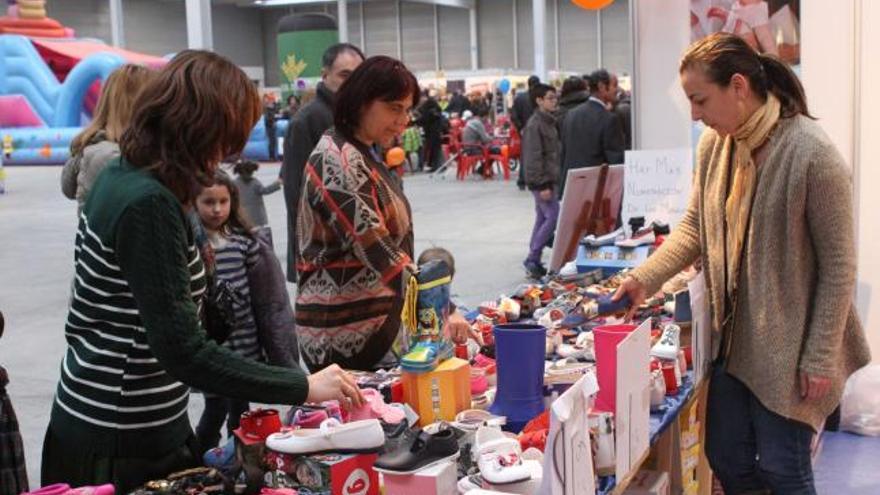 Varios clientes se interesan por el calzado infantil que exponía uno de los comercios participantes.