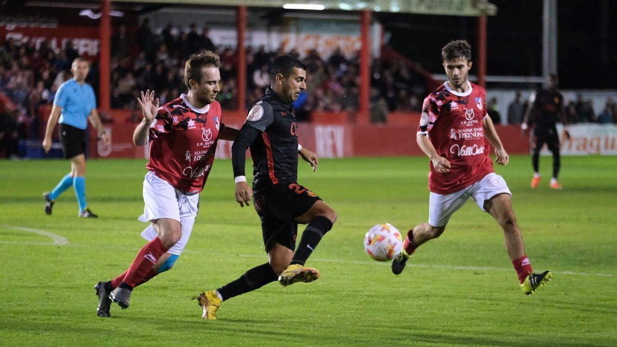 Ángel controla el balón antela presión de dos rivales.