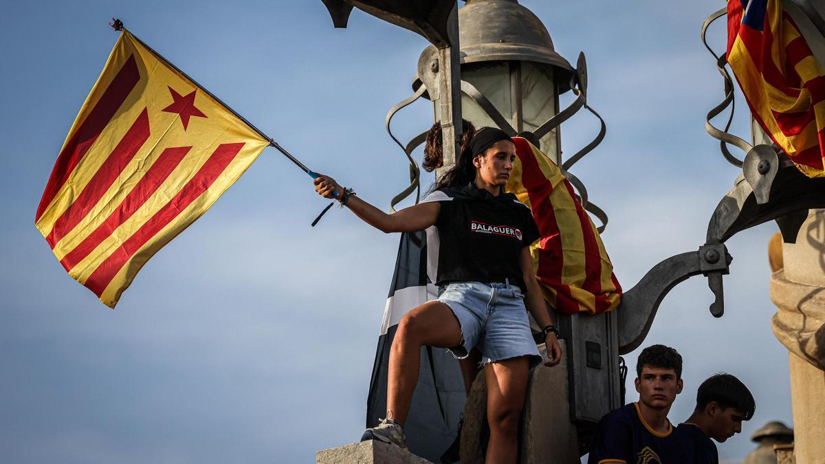 Una manifestant amb una estelada a la plaça d'Espanya, participant a la manifestació convocada per l'ANC amb motiu de la Diada del 2023