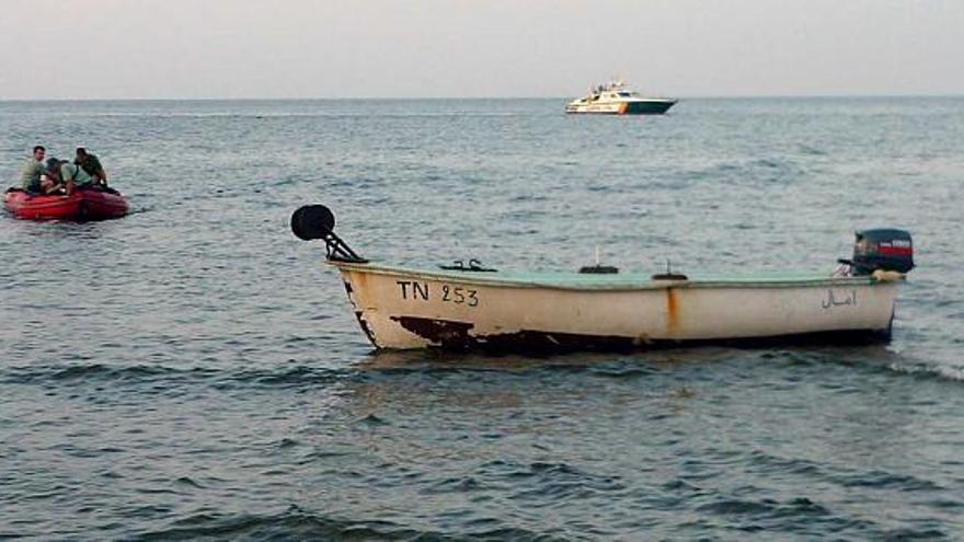 La patera junto a una zódiac de la Guardia Civil y al fondo la patrullera del Servicio Marítimo.