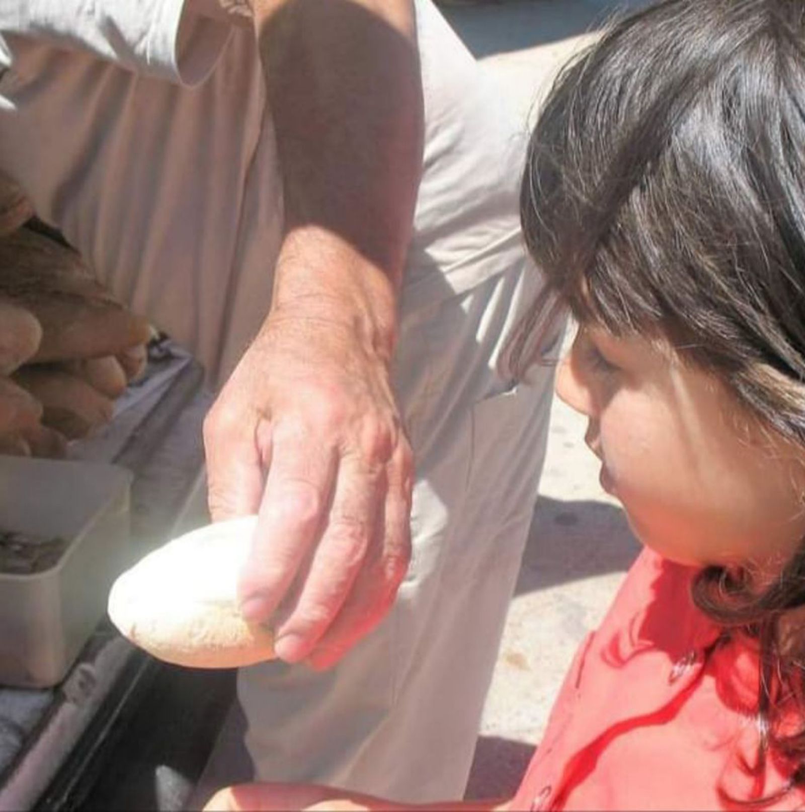 Toribio le da un chusco de pan a una niña. | Puri Sanabria