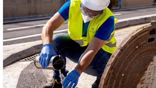 Un técnico, recogiendo aguas residuales para nu análisis.