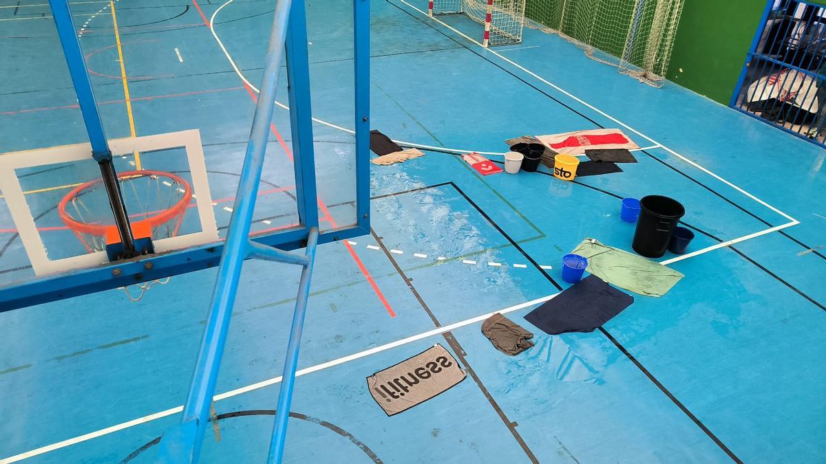 Estado de la cancha con cubos para recoger el agua.