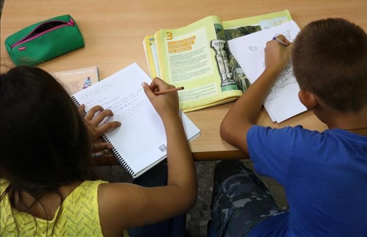 Dos niños hacen los deberes solos sin ayuda de adultos. Dos niños hacen los deberes solos sin ayuda de adultos.