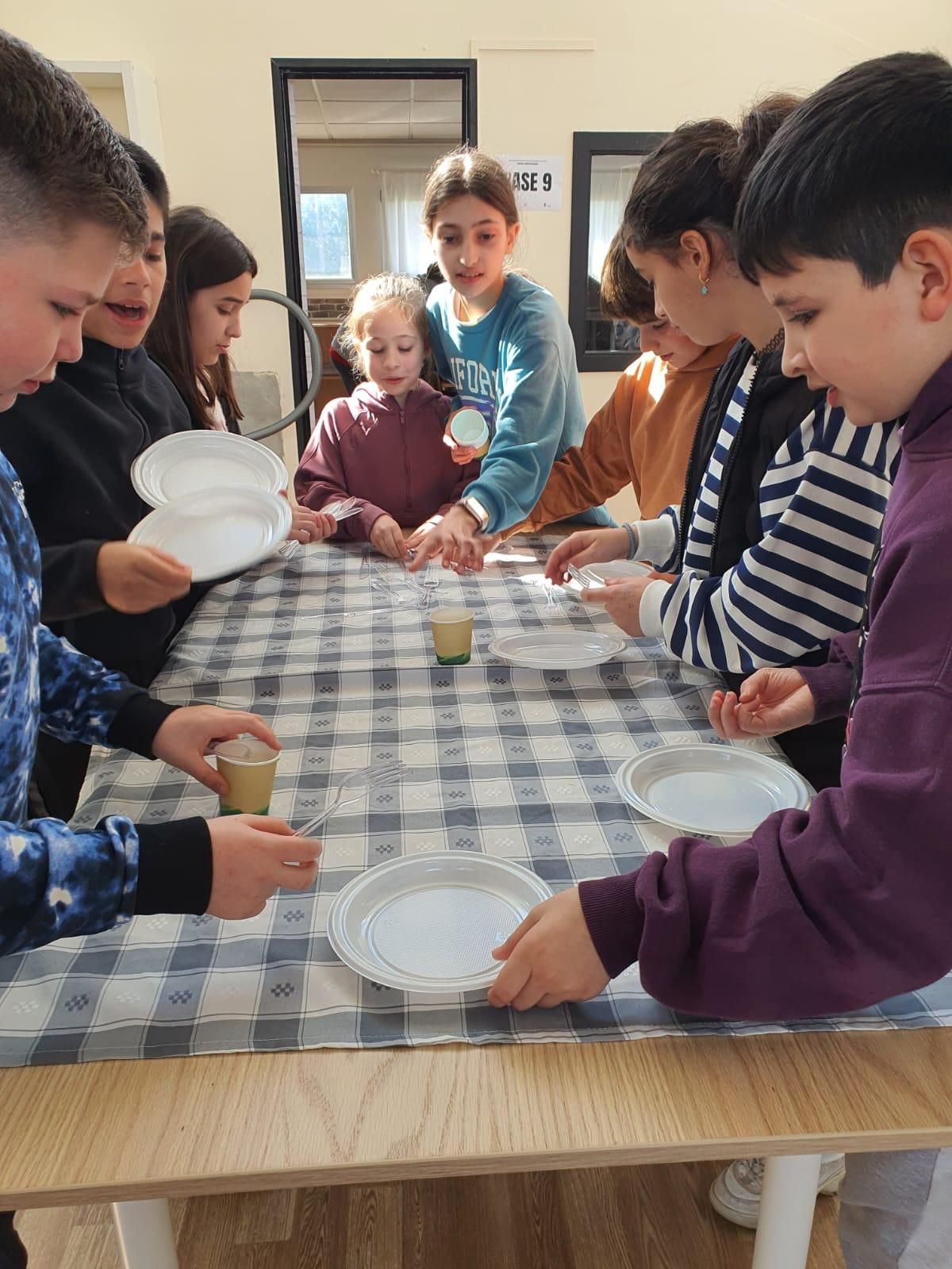 Niños y niñas de Valga realizando labores domésticas en igualdad.