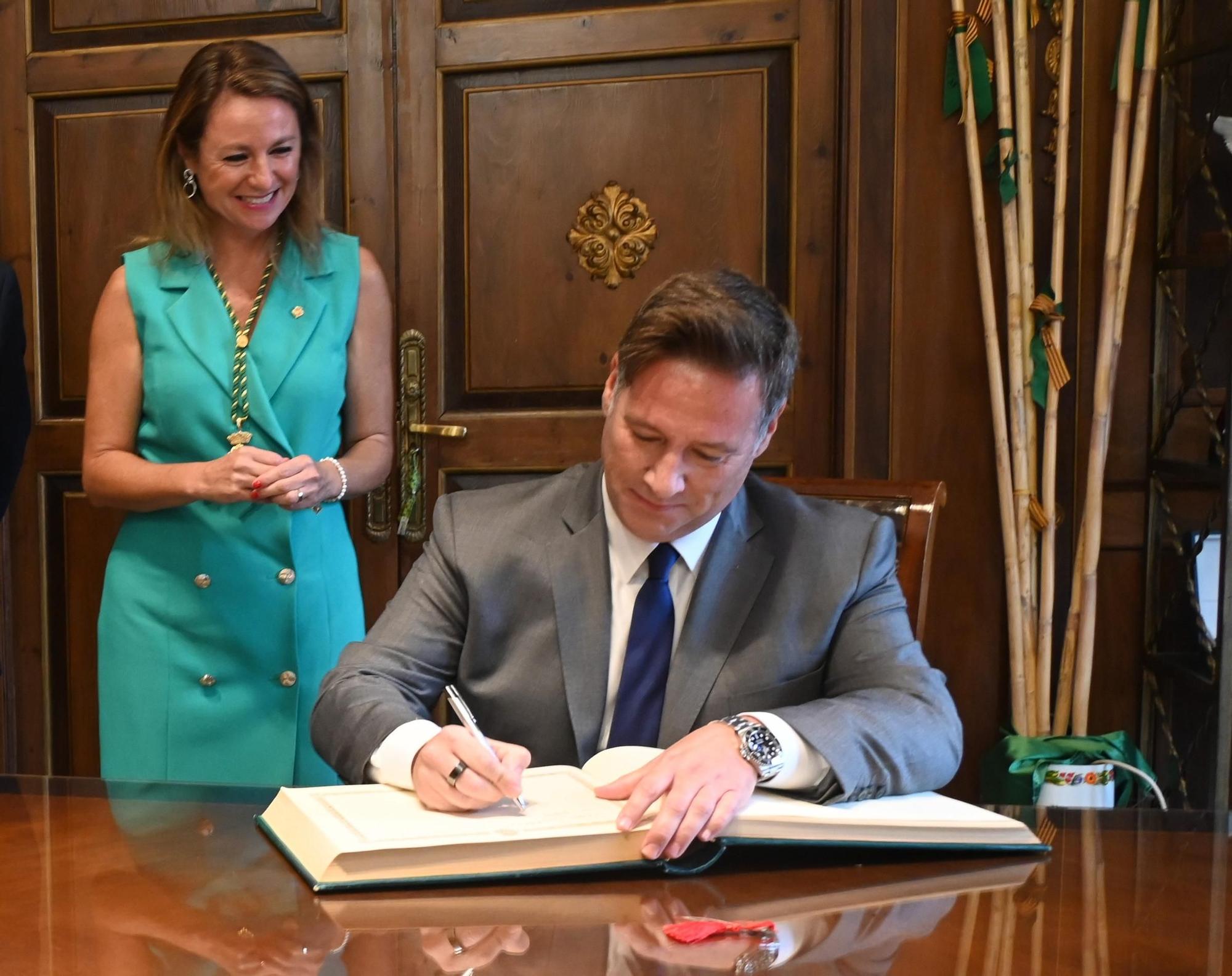 Latre firma en el libro de honor en presencia de la alcaldesa de Castelló.