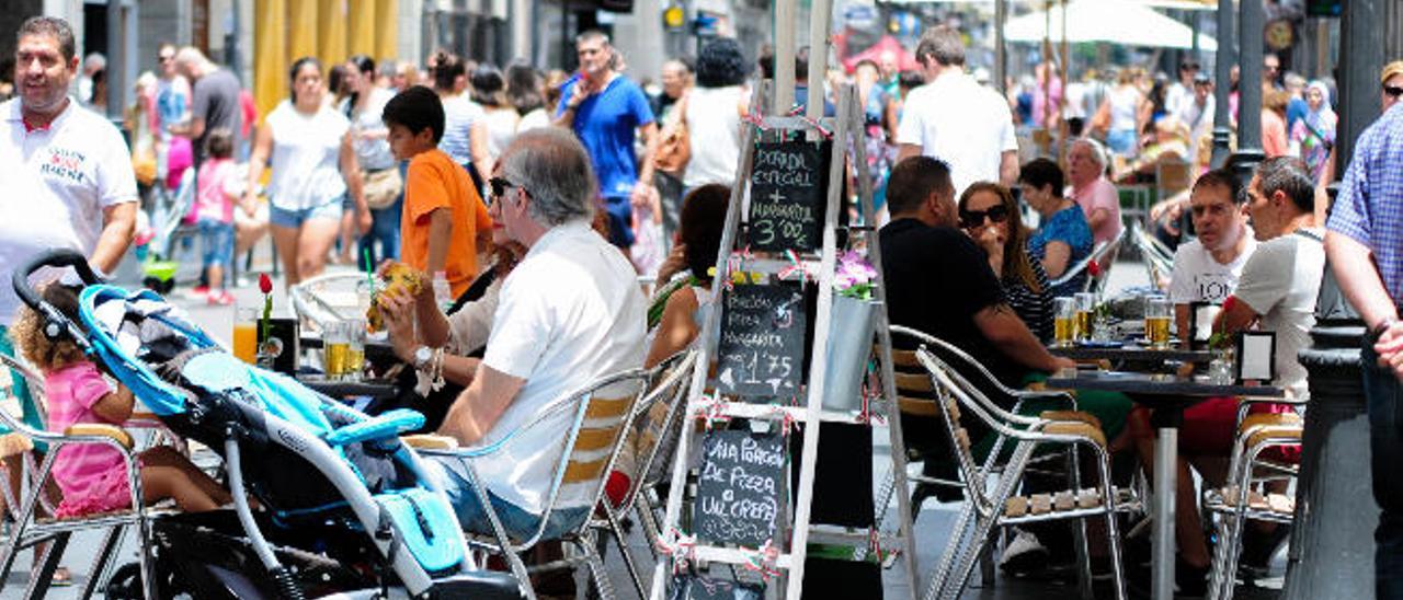 La calle Triana en una imagen retrospectiva con viandantes paseando al lado de las terrazas.