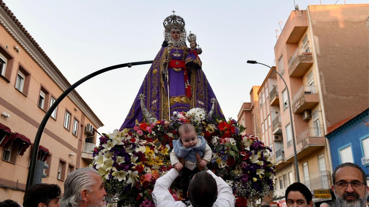 Un hombre levanta a su hijo ante la imagen de la Fuensanta a su llegada a la ciudad de Murcia.