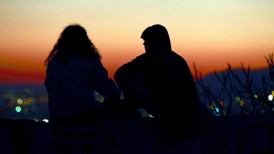 Dos personas observan el atardecer desde los miradores del barrio de El Carmel de Barcelona.