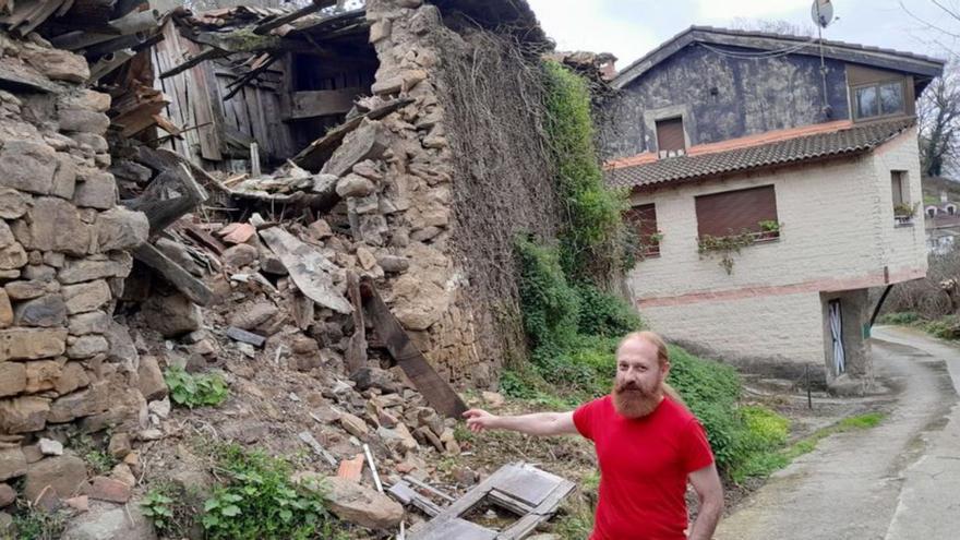 Alberto Fuentes, junto a las casas en ruina, con su vivienda detrás. | LNE