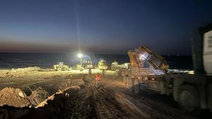 Construcción en una playa de Gaza del espigón para la descarga de la ayuda humanitaria que transporta el buque Open Arms.