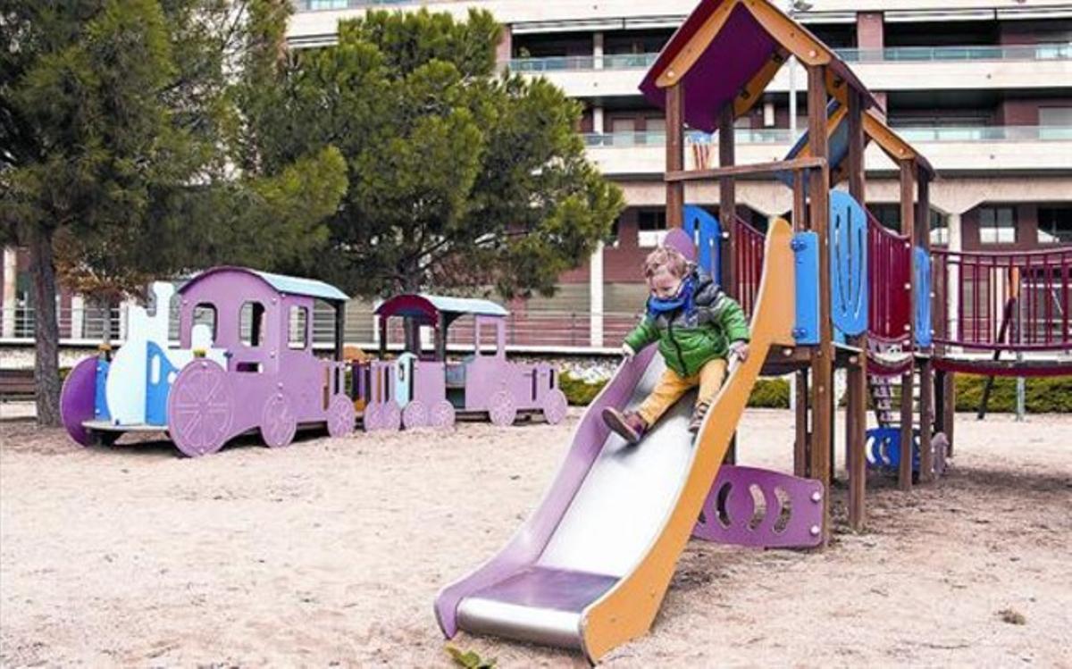 Un niño juega en un tobogán en el parque de la plaza de Ernest Lluch, en Lleida.