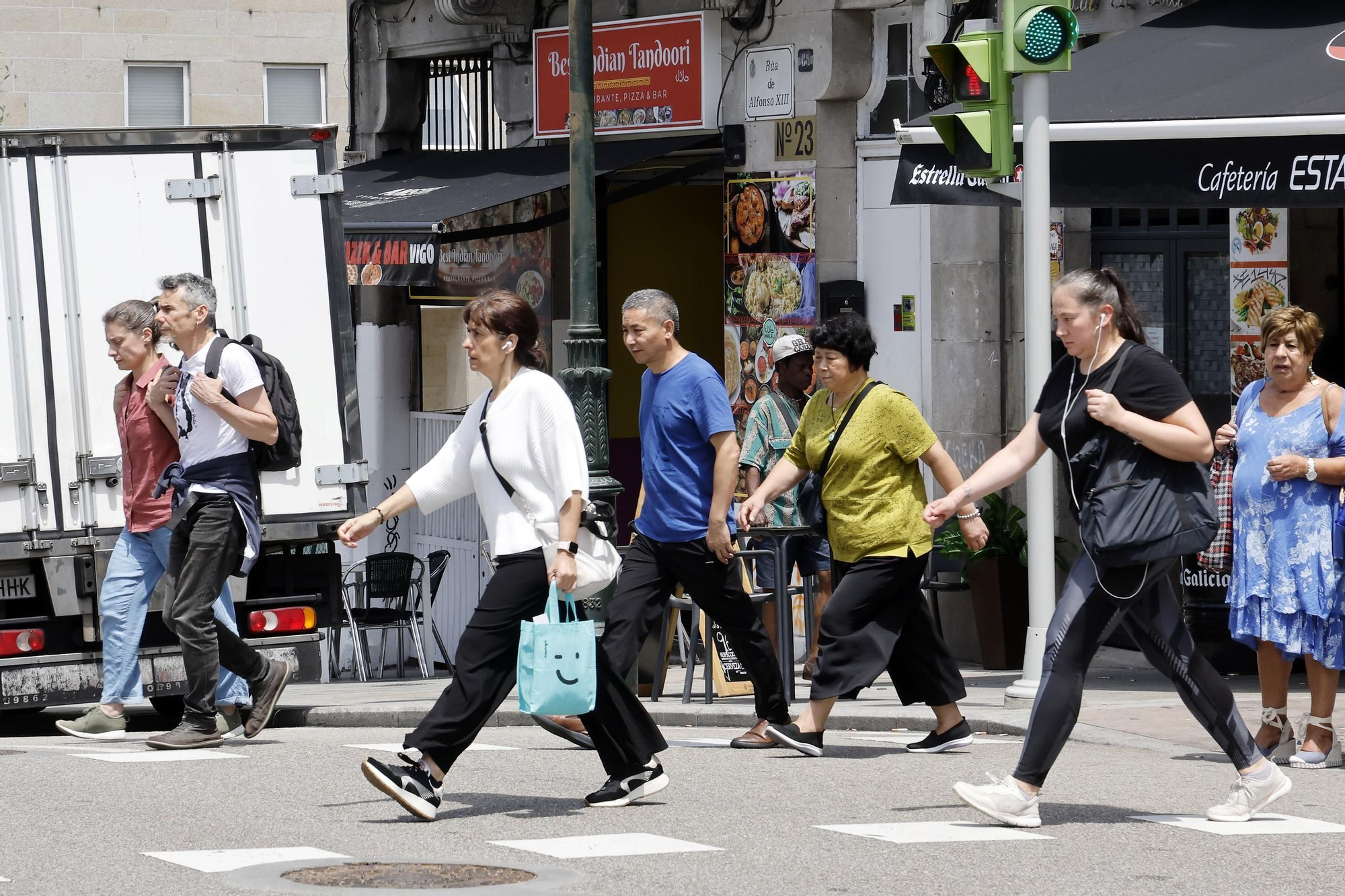 Peatones cruzando la carretera con el semáforo en rojo en la calle Alfonso XIII de Vigo