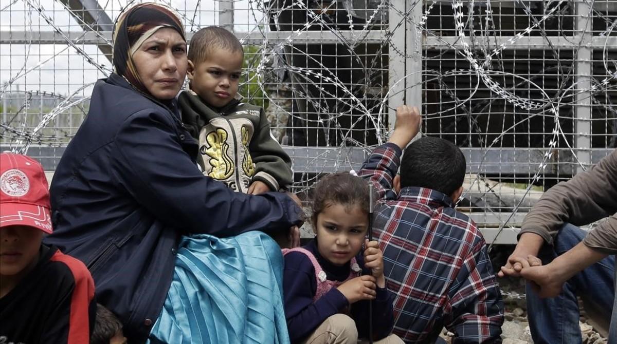 mbenach33771071 migrants and refugees sit near the fence during a 160506164901