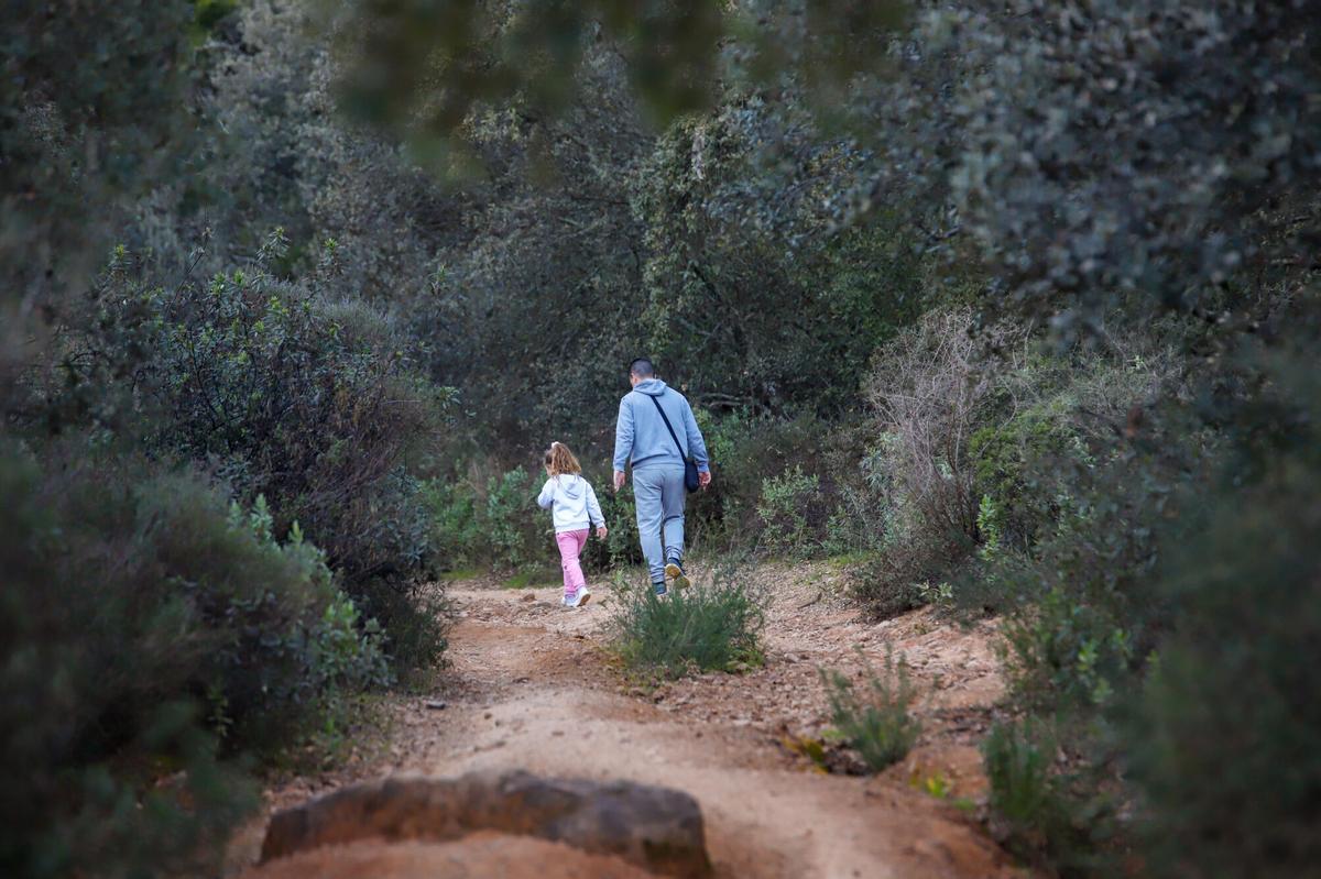 Un padre y su hija caminan por la ruta senderista.