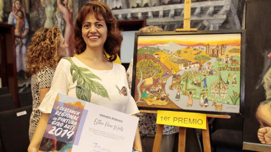 Los premiados, durante el acto en el que se entregaron los reconocimientos.
 La ganadora del certamen Esther Pérez junto a su obra Después de la Romería de La Orotava.